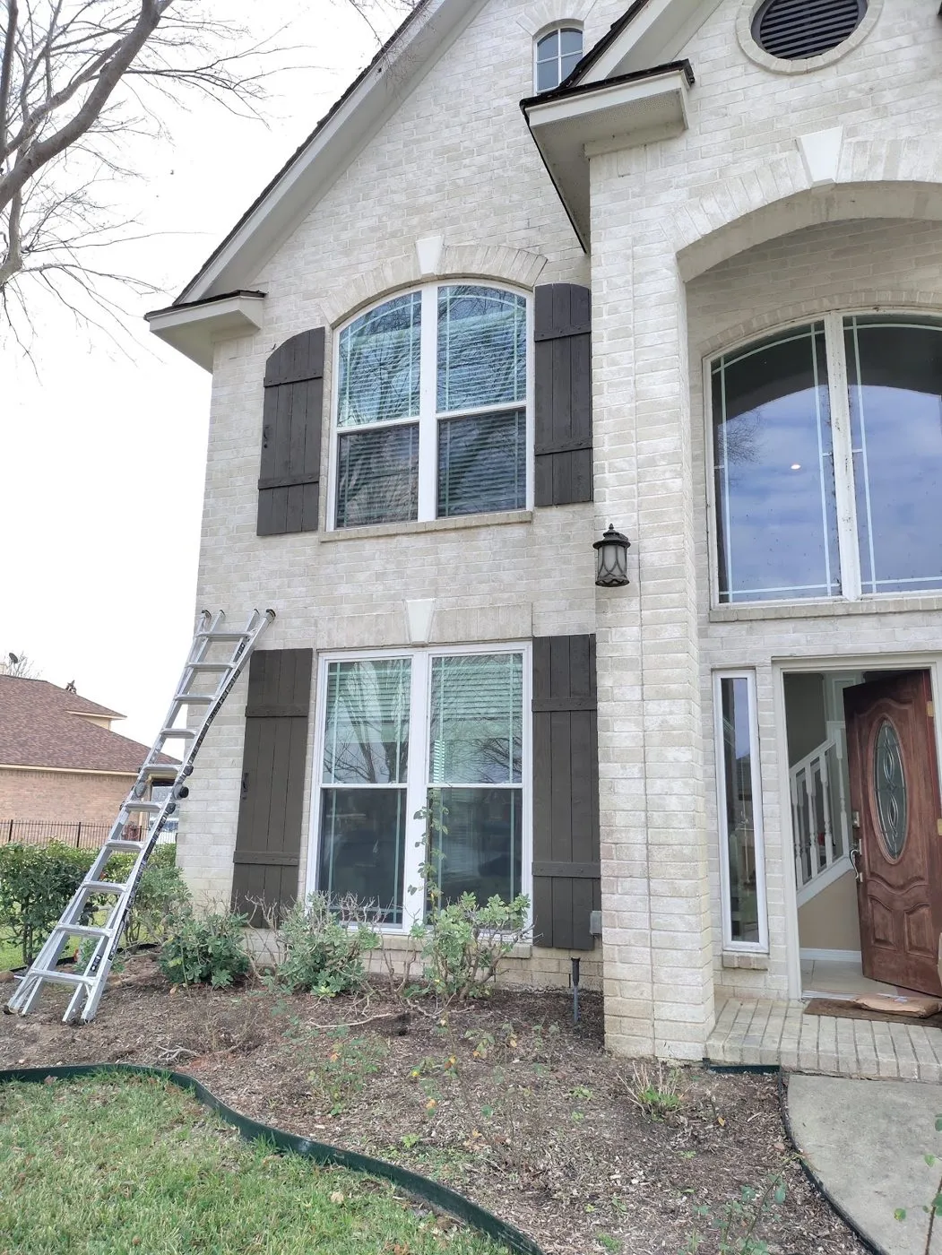Brick house exterior with a ladder at the front