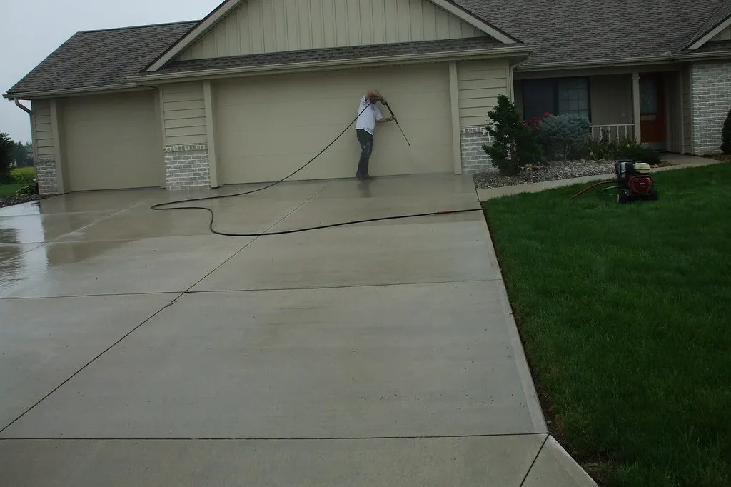 Freshly pressure washed concrete driveway in front of a garage